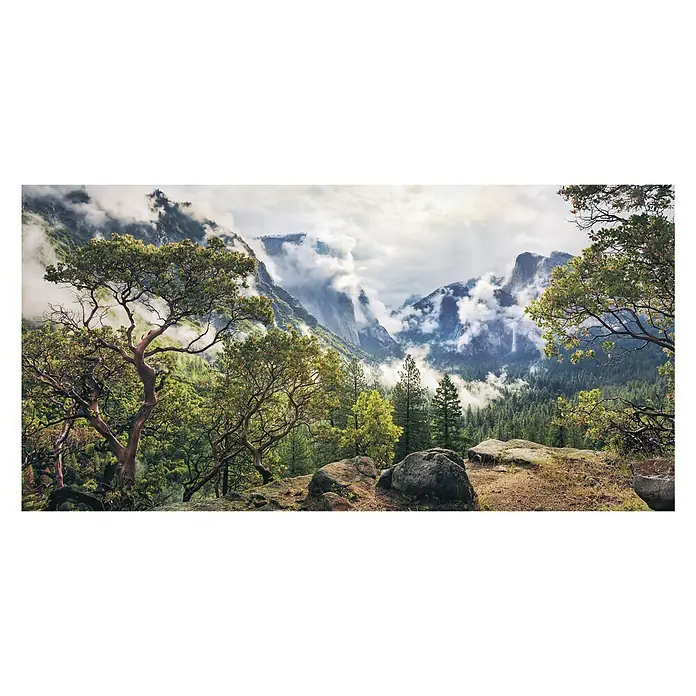 Komar Stefan Hefele Edition 1 Fototapete Unique Paradise - 1 -tlg., B x H: 200 x 100 cm, Vlies - Malerischer Blick auf ein grünes Tal mit Bäumen und Felsen, im Hintergrund majestätische Berge unter einem bewölkten Himmel.