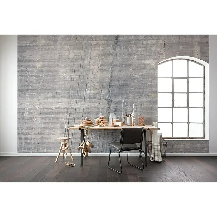 Komar Pure Fototapete Concrete - 4 -tlg., B x H: 400 x 250 cm, Vlies - Ein stilvolles Interieur mit Holzboden, rustikaler Wand und einem Tisch mit dekorativen Elementen. Ein Schreibtischstuhl und ein Fenster runden das Bild ab.