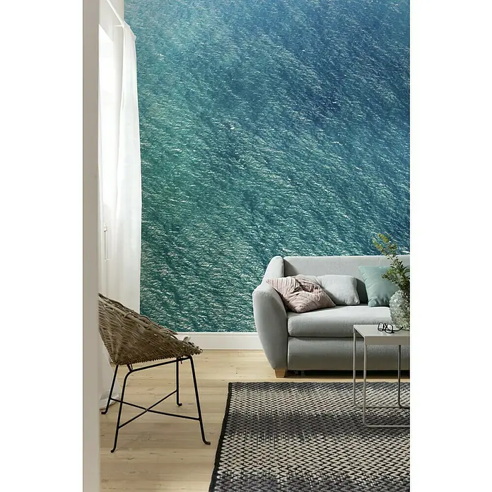 Komar Pure Fototapete Blaupause - 4 -tlg., B x H: 400 x 250 cm, Vlies - Wohnzimmer mit hellgrauem Sofa, Teppich und Meerblick-Tapete, die eine entspannende Atmosphäre schafft. Der Sessel und Tisch ergänzen das moderne Interieur.