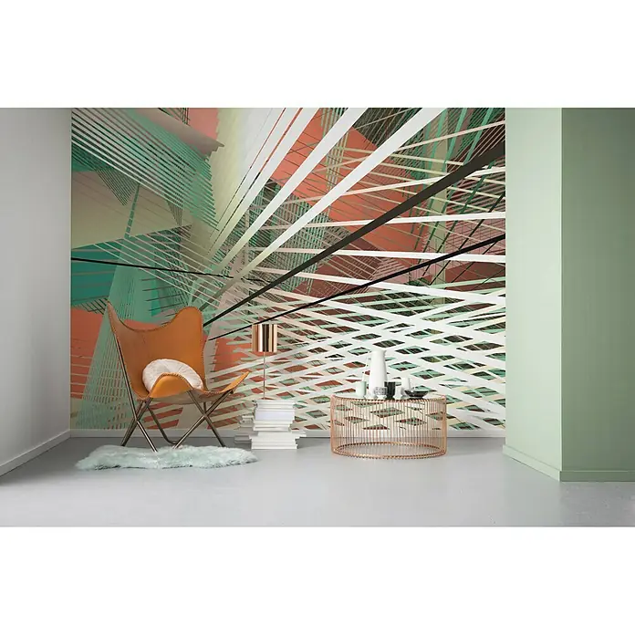Komar Infinity Fototapete Space Grid Autumn - 4 -tlg., B x H: 400 x 250 cm, Vlies - Ein Innenraum mit einem auffälligen grafischen Wandbild, einem Ledersessel und einem runden Tisch mit Deko-Objekten.
