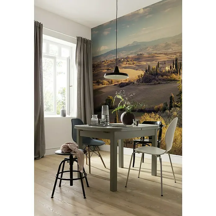 Komar Pure Fototapete Toskanagold - 4 -tlg., B x H: 400 x 250 cm, Vlies - Einladender Essbereich mit grauem Esstisch unter einer Pendelleuchte, ergänzt durch Stühle und eine malerische Landschaftstapete.