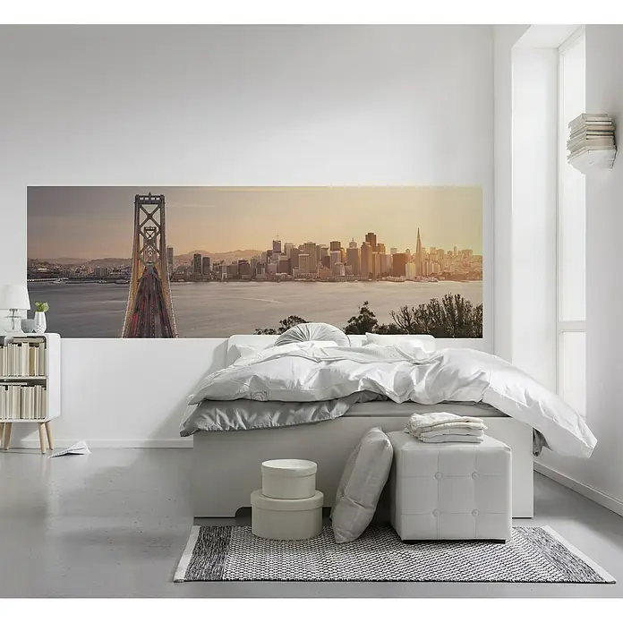 Komar Stefan Hefele Edition 1 Fototapete California Dreaming - 1 -tlg., B x H: 300 x 100 cm, Vlies - Ein Schlafzimmer mit einem großen Wandbild von San Francisco über dem Bett, das die Skyline und eine Brücke zeigt.
