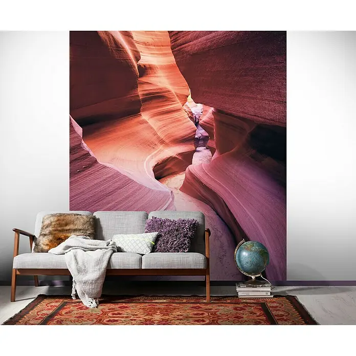 Komar Stefan Hefele Edition 1 Fototapete Lost in Color - 2 -tlg., B x H: 200 x 250 cm, Vlies - Ein Wohnzimmer mit einem grauen Sofa, Kissen, Teppich und einem atemberaubenden Wandbild eines Canyons.