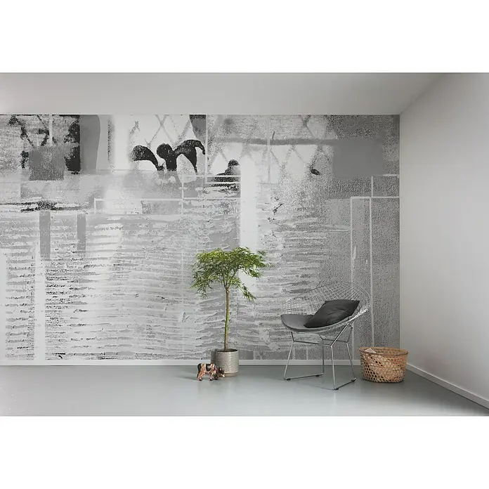 Komar Pure Fototapete Rhombus Hiding - 5 -tlg., B x H: 500 x 280 cm, Vlies - Ein stilvolles Zimmer mit einem Drahtsessel, einer Pflanze und einem dekorativen Korb. Die Wandgestaltung verleiht dem Raum eine moderne Note.