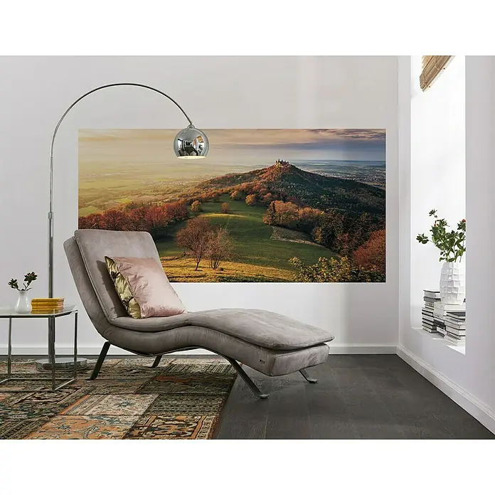 Komar Stefan Hefele Edition 1 Fototapete Fairy Tale Castle - 1 -tlg., B x H: 200 x 100 cm, Vlies - Bild eines grauen Sessels mit Kissen vor einem Hintergrundbild, einer Stehlampe und einem Beistelltisch.