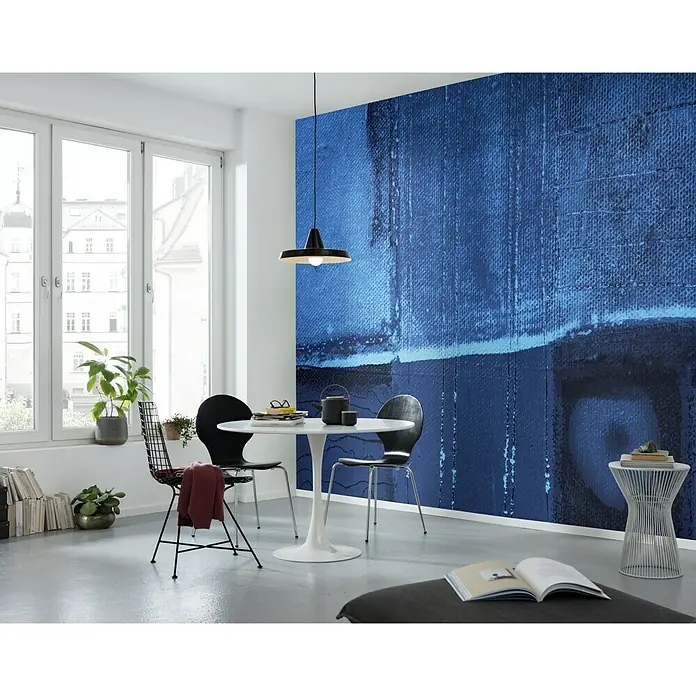 Komar Pure Fototapete Creeks Crossing - 5 -tlg., B x H: 500 x 280 cm, Vlies - Eine moderne Esszene mit einem runden Tisch, Stühlen und einer auffälligen blauen Wandkunst, die dem Raum einen Farbtupfer verleiht.