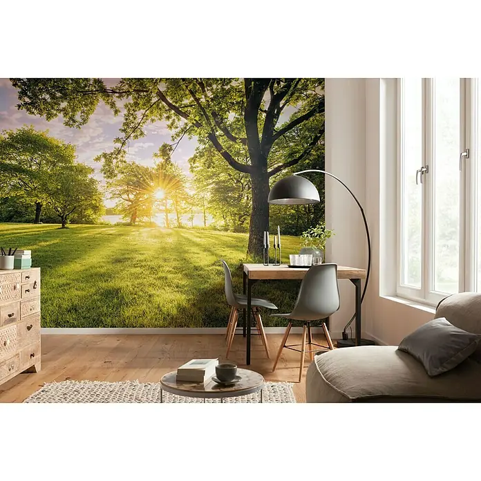 Komar Pure Fototapete Golden Moment - 4 -tlg., B x H: 400 x 250 cm, Vlies - Wohnraum mit Fototapete, die einen sonnigen Park zeigt, ergänzt durch eine moderne Einrichtung mit Tisch, Stühlen und Sofa.