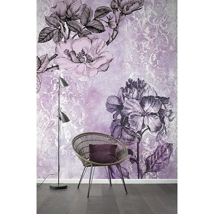 Komar Infinity Fototapete Baroque Pink - 2 -tlg., B x H: 200 x 250 cm, Vlies - Stilvoller Raum mit Korbsessel und floral gemusterter Tapete in Lila- und Rosatönen, ergänzt durch eine moderne Stehlampe und dunklen Holzboden.