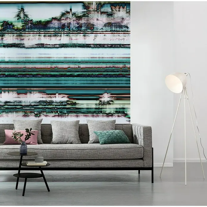 Komar Pure Fototapete Miami Radio - 8 -tlg., B x H: 200 x 250 cm, Vlies - Graues Sofa mit Kissen und einem Beistelltisch vor einer Wand mit Kunst. Eine Stehlampe steht daneben.