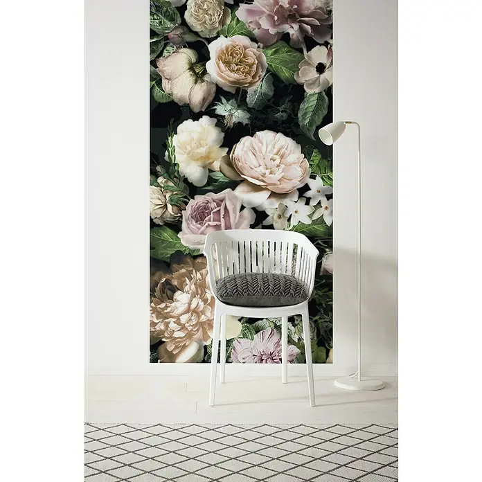 Komar Infinity Fototapete Victoria Black - 1 -tlg., B x H: 100 x 250 cm, Vlies - Detailaufnahme einer weißen Stuhl mit grauem Kissen vor dunkler Blumentapete, ergänzt durch eine Stehlampe und einen gemusterten Teppich.