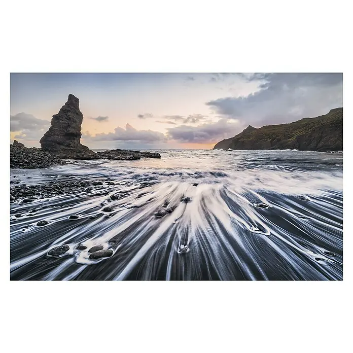 Komar Stefan Hefele Edition 1 Fototapete Smooth - 4 -tlg., B x H: 400 x 250 cm, Vlies - Dramatische Küstenlandschaft mit Felseninsel und fließendem Wasser über dunklem Sand, eingefangen in malerischer Abenddämmerung.