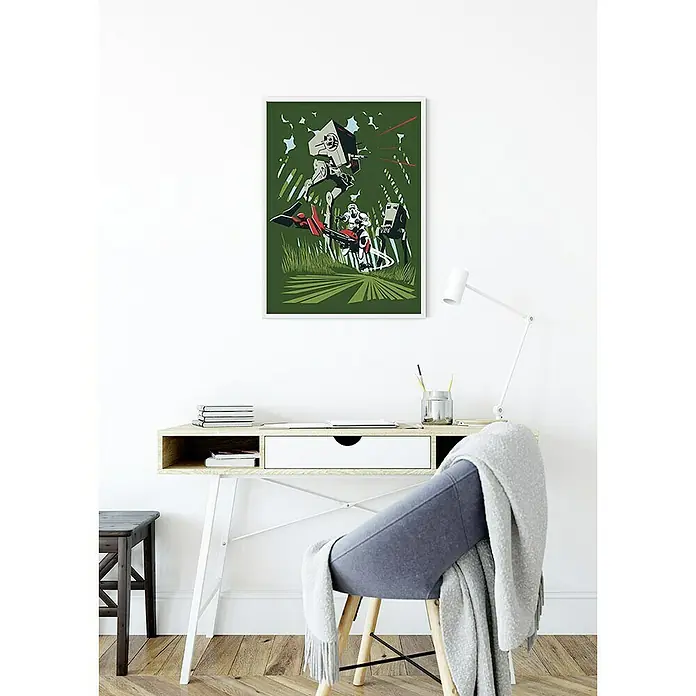 Komar Star Wars Poster Vector Endor - Star Wars, B x H: 30 x 40 cm - Ein gerahmtes Star Wars-Poster mit einem AT-ST und einem Speederbike hängt über einem Schreibtisch mit einer Lampe, Büchern und Büromaterialien.
