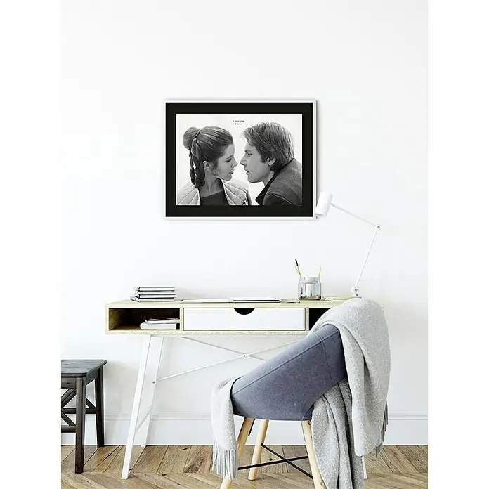 Komar Star Wars Poster Leia Han Love - Star Wars, B x H: 40 x 30 cm - Schwarz-Weiß-Foto von Leia und Han Solo mit dem Zitat "I love you/I know" über einem hellen Schreibtisch mit Stuhl und Lampe.