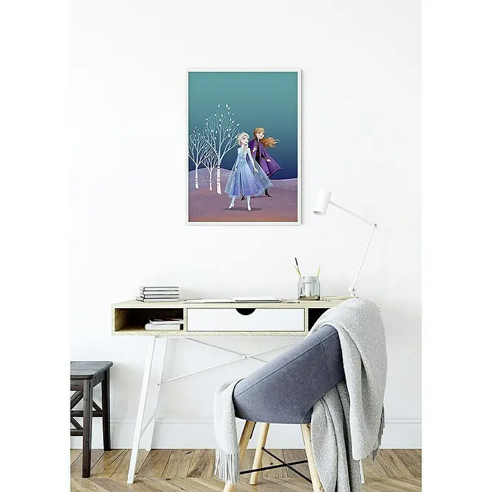 Komar Disney Edition 4 Poster Frozen Sisters - Disney, B x H: 40 x 50 cm - Ein gerahmtes Frozen-Poster mit Anna und Elsa hängt über einem Schreibtisch mit einem Stuhl davor, der mit einer Decke bedeckt ist.