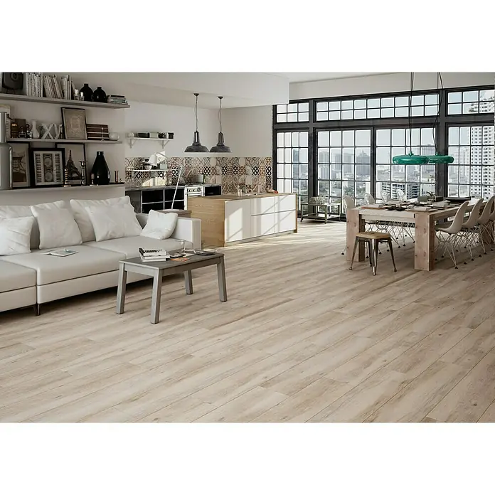 Halcón Pavimento porcelánico Atelier - 23,3 x 120 cm, Taupe, Clase 2 - Salón luminoso con suelo de madera, sofá, mesa y cocina abierta, ideal para conceptos de vida modernos con suelos de madera elegantes.