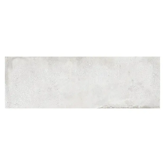 Revestimiento de pared Origin - 90 x 30 cm, Caliza, Rectificado - Baldosa gris alargada con una ligera textura. La baldosa es de color gris claro y tiene una superficie ligeramente irregular, dándole un aspecto rústico.