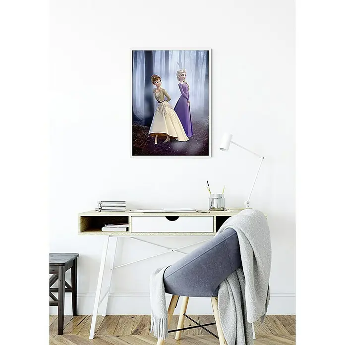 Komar Disney Edition 4 Poster Frozen Wood Walk - Disney, B x H: 40 x 50 cm - Ein gerahmtes Frozen-Poster mit Anna und Elsa, das über einem Schreibtisch mit Stuhl hängt, verleiht dem Raum eine spielerische Note.
