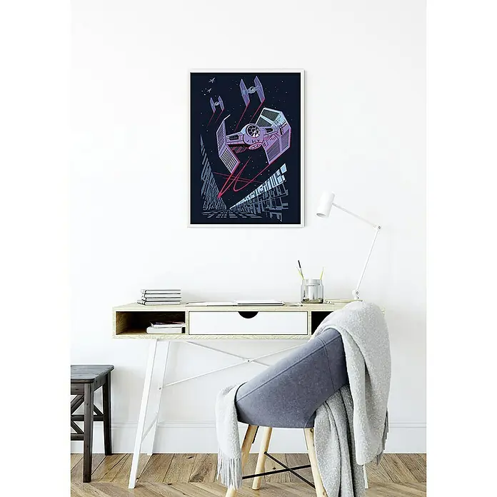 Komar Star Wars Poster Vector TIE-Fighter - Star Wars, B x H: 50 x 70 cm - Ein Star Wars TIE Fighter Kunstdruck im Rahmen, der eine dynamische Szene aus dem Film zeigt, hängt an einer weißen Wand über einem Schreibtisch.