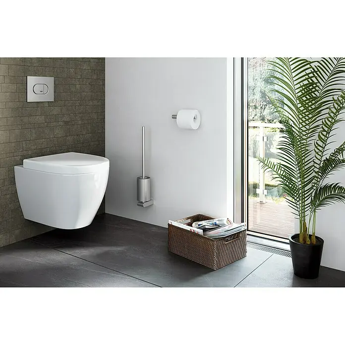 Zack Atore Toilettenpapierhalter 1 - Ohne Deckel, Edelstahl, Matt - Eine moderne Toilette mit Wandmontage, WC-Bürste, Papierhalter und einem Korb mit Zeitschriften in einem stilvollen Badezimmer.