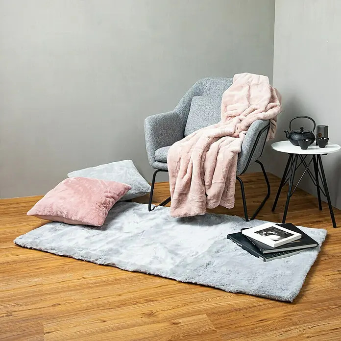 Kissen HappyPuderrosa, 48 x 48 cm, 100 % Polyester - Flauschiger grauer Teppich mit rosa Kissen, grauem Sessel und Beistelltisch. Ideal für gemütliche Momente und eine stilvolle Einrichtung.
