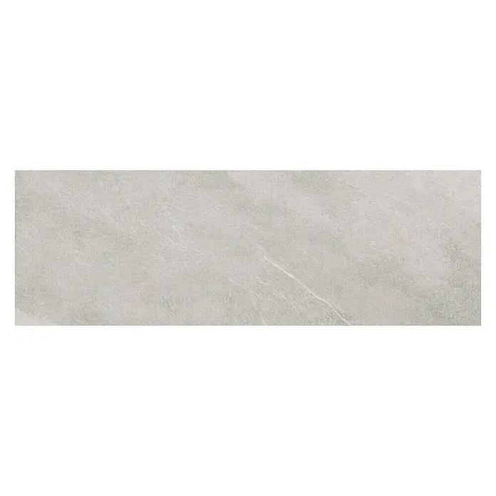 Revestimiento de pared Apuan - 90 x 30 cm, Blanco, Rectificado - La imagen muestra una sola baldosa de cerámica alargada de color gris claro con un sutil patrón marmoleado. La baldosa tiene un acabado mate y es ideal para revestimientos.