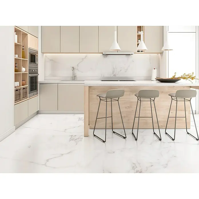 Halcón Pavimento porcelánico Palatina - 60 x 120 cm, Blanco Carrara, Mate, Espesor: 7,4 mm - Vista de cocina con elegantes taburetes de bar frente a una isla, destacando el diseño moderno.