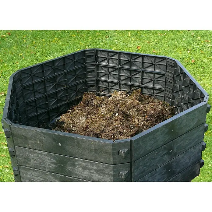 KHW Komposter SK 550 Basismodul - 550 l, Ø x H: 130 x 50 cm - Ein detailreiches Bild eines Kompostbehälters aus Kunststoff, gefüllt mit organischem Material, im Freien auf einer grünen Rasenfläche.