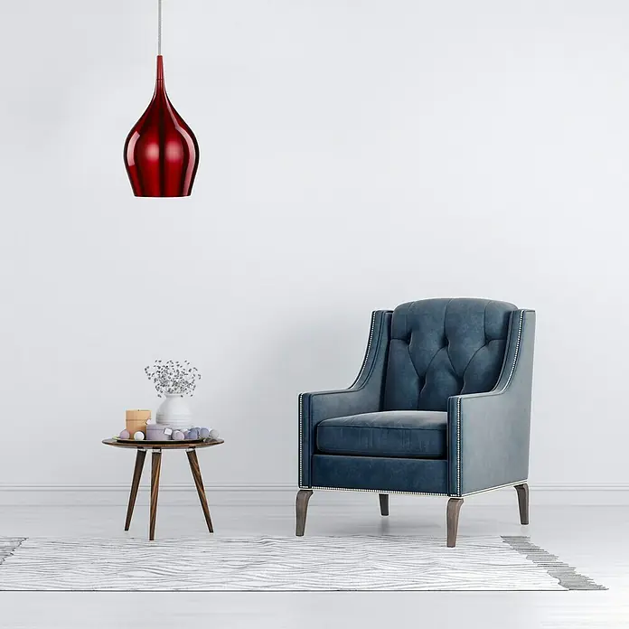 Searchlight Pendelleuchte Vibrant - 40 W, L x B x H: 12 x 12 x 142 cm, Rot, E14, 120 mm - Elegantes Interieur mit einem blauen Sessel, einem stilvollen Beistelltisch und einer auffälligen roten Pendelleuchte.