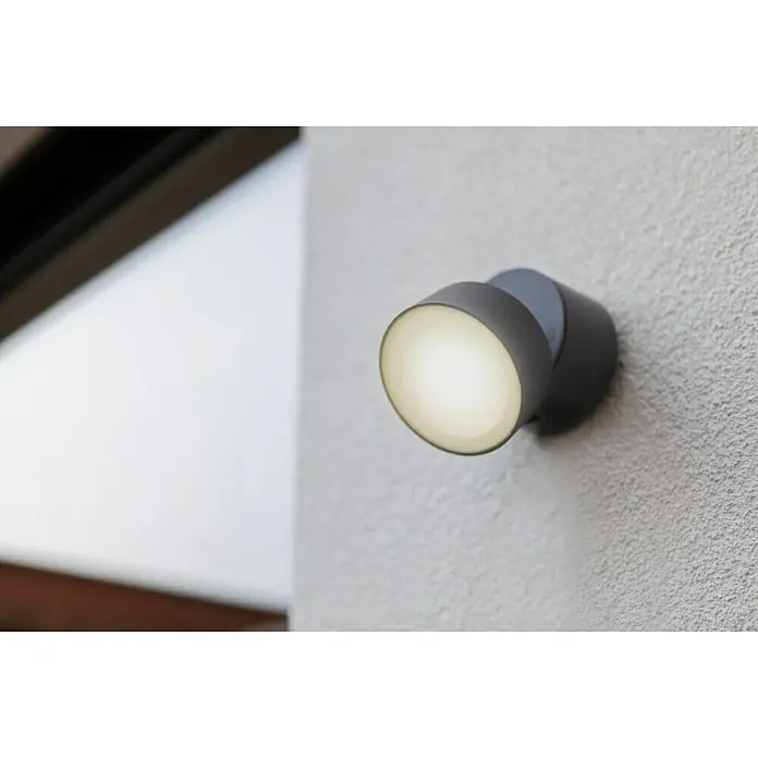Lutec LED-Außenwandleuchte - 6,7 W, Anthrazit - Nahaufnahme einer modernen, runden Wandleuchte in Grau, die ein warmes, helles Licht abstrahlt.