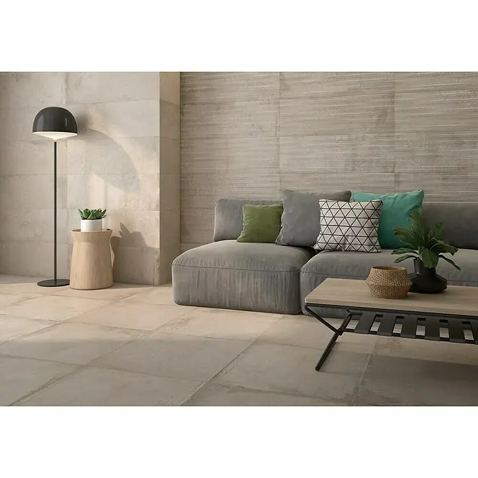 Pavimento porcelánico Origin - 60 x 60 cm, Arena, Mate - Acogedora sala de estar con baldosas de gran formato con aspecto de piedra, creando un ambiente cálido y moderno.