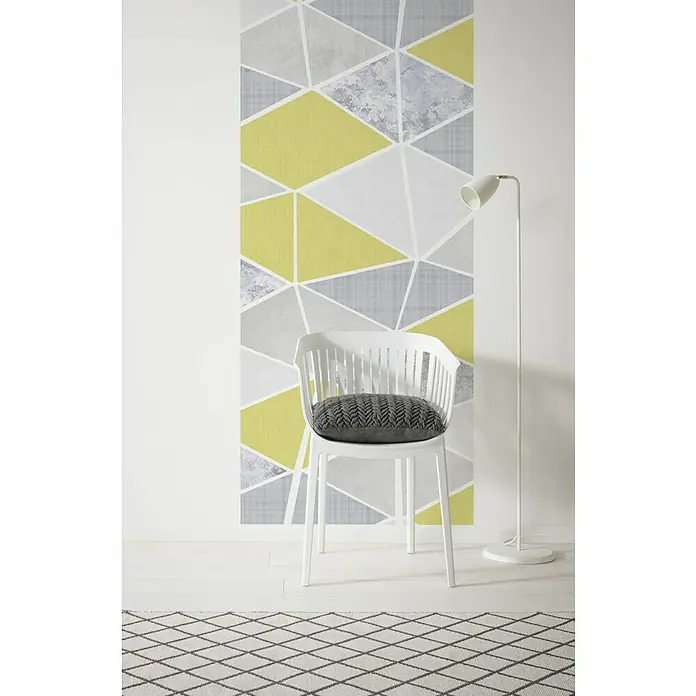 Komar Infinity Fototapete Yesterday Panel - 1 -tlg., B x H: 100 x 250 cm, Vlies - Moderner Raum mit einem weißen Stuhl mit grauem Kissen und einer geometrischen Wand. Die schlanke Stehlampe ergänzt das stilvolle Interieur.