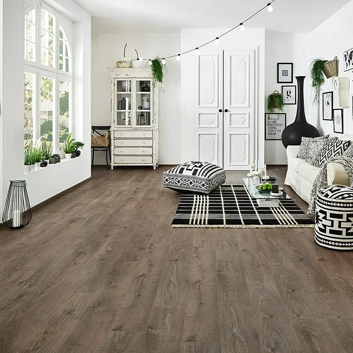 LOGOCLIC Silentos Laminat Eiche Fondi1.285 x 192 x 9 mm, Landhausdiele, Eiche Fondi - Ein stilvolles Wohnzimmer mit Holzboden, weißen Wänden und Akzenten in Schwarz-Weiß, die eine moderne und gemütliche Atmosphäre schaffen.