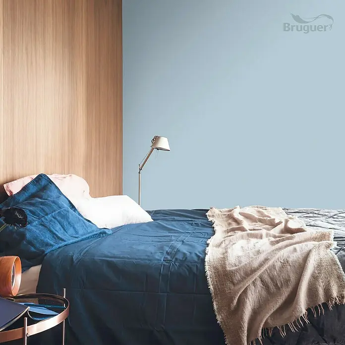 Bruguer Colores del Mundo Tester de pintura - Mediterráneo azul intermedio, Mate, 30 ml - Cama con ropa de cama azul, pared pintada de azul claro y paneles de madera para un ambiente acogedor en el dormitorio con una paleta de colores relajante.