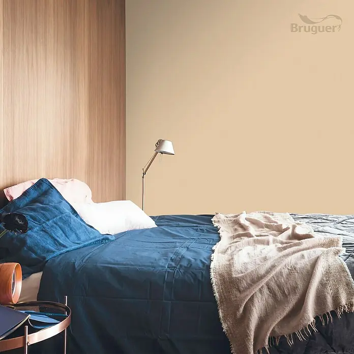 Bruguer Colores del Mundo Tester de pintura - Egipto ocre intermedio, Mate, 30 ml - Elegante dormitorio con cama doble, ropa de cama azul, una manta beige y una lámpara decorativa para crear un ambiente acogedor.
