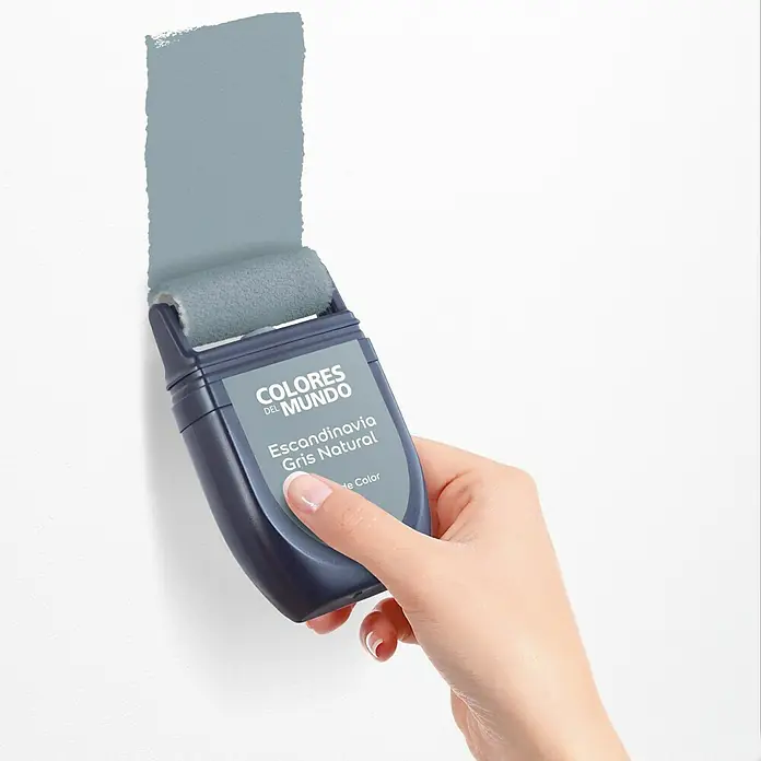 Bruguer Colores del Mundo Tester de pintura - Escandinavia gris natural, Mate, 30 ml - Primer plano de un rodillo de pintura "Colores del Mundo" con pintura "Scandinavia Gris Natural" aplicándose a una pared blanca.