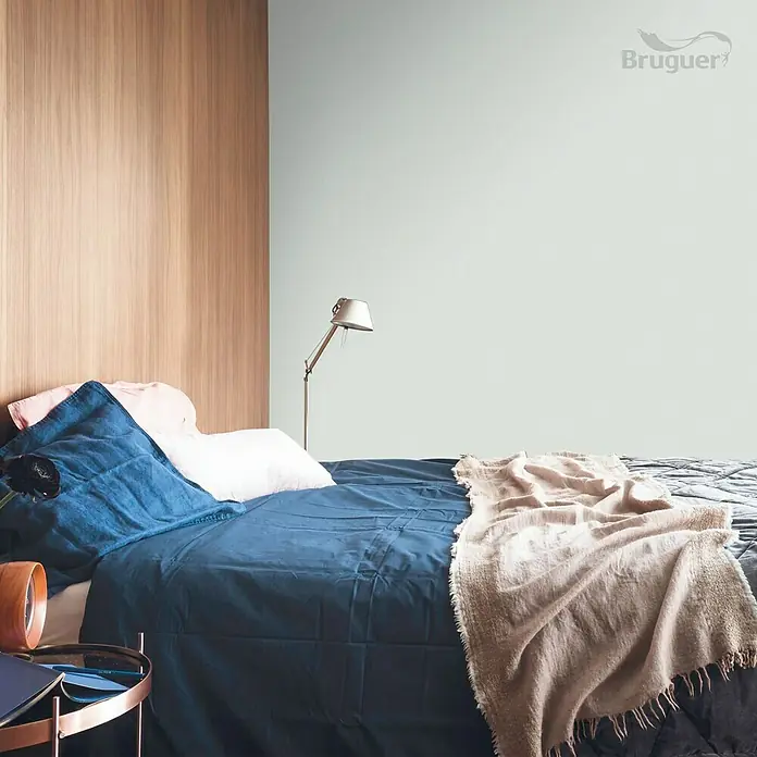 Bruguer Colores del Mundo Tester de pintura - Amazonas matiz de verde, Mate, 30 ml - Acogedora habitación con ropa de cama azul, pared de madera y pared verde menta, creando un ambiente tranquilo y relajante.