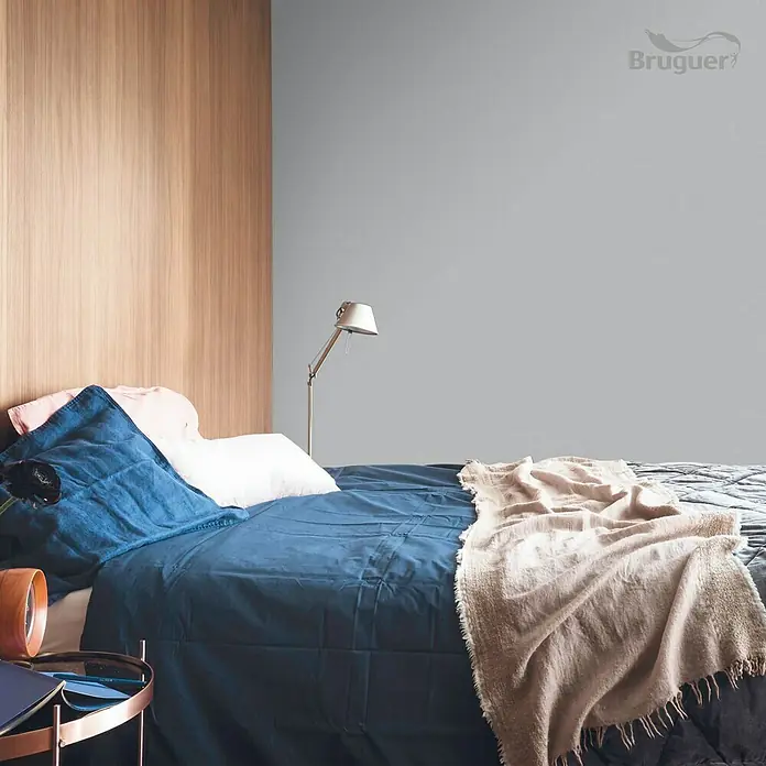 Bruguer Colores del Mundo Tester de pintura - Escandinavia gris suave, Mate, 30 ml - Dormitorio con cama azul, pared de madera y pared gris pintada con pintura Bruguer.