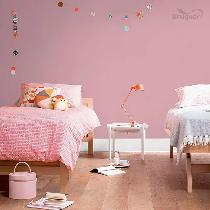 Bruguer Ultra Resist Tester de pintura - Lila nocturno, Mate, 30 ml - Dos camas infantiles en una habitación rosa con guirnaldas y lámpara, creando un ambiente acogedor y divertido.