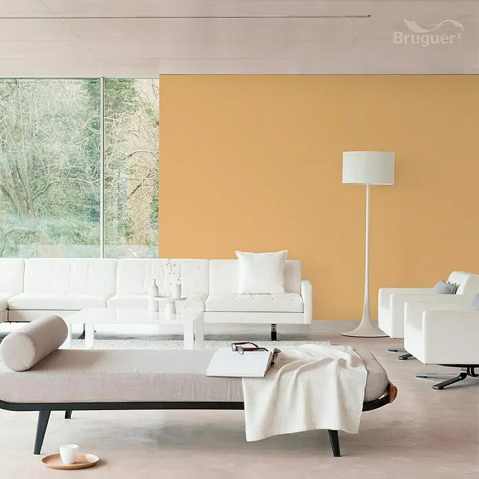 Bruguer Ultra Resist Tester de pintura - Amarillo imperial, Mate, 30 ml - Salón luminoso con sofá blanco, sillones y un diván con manta. Una lámpara de pie y el fondo amarillo acentúan el espacio.