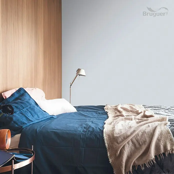Bruguer Colores del Mundo Tester de pintura - Mediterráneo matiz de lila, Mate, 30 ml - Dormitorio con pintura Bruguer en la pared, ropa de cama azul y toques de madera para un ambiente sereno y moderno.