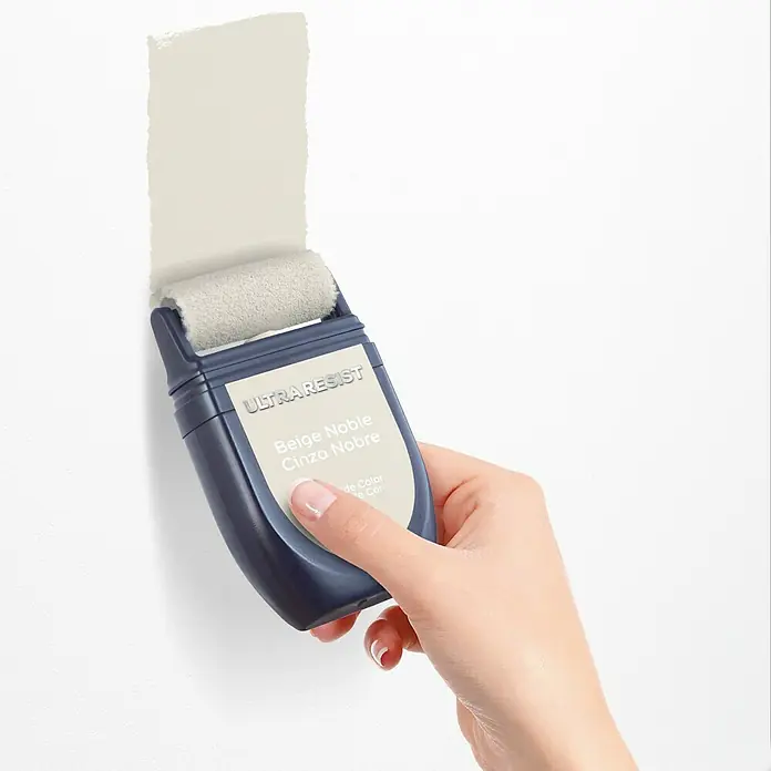 Bruguer Ultra Resist Tester de pintura - Beige noble, Mate, 30 ml - Primer plano de un rodillo aplicador de pintura Ultraresist con pintura beige que se aplica a una pared blanca.