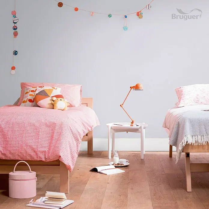 Bruguer Ultra Resist Tester de pintura - Lila floral, Mate, 30 ml - Dos camas en una habitación infantil con accesorios, complementadas con una lámpara sobre una mesita para un ambiente acogedor.