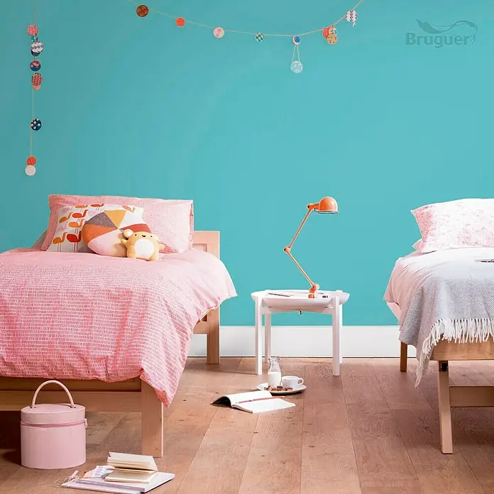 Bruguer Ultra Resist Tester de pintura - Azul turquesa, Mate, 30 ml - Habitación infantil luminosa con dos camas individuales, una mesita de noche blanca con lámpara y adornos de pared coloridos.