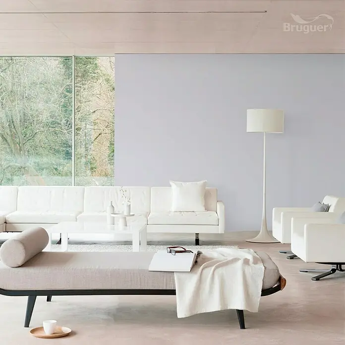 Bruguer Ultra Resist Tester de pintura - Lila floral, Mate, 30 ml - Salón luminoso y moderno con sofá blanco, sillón y elegante diván. La pared está pintada en un suave tono lila.