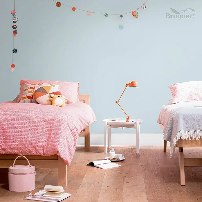 Bruguer Ultra Resist Tester de pintura - Azul relajado, Mate, 30 ml - Habitación infantil con dos camas, una mesita de noche y una lámpara naranja, decorada con guirnaldas y accesorios de colores.