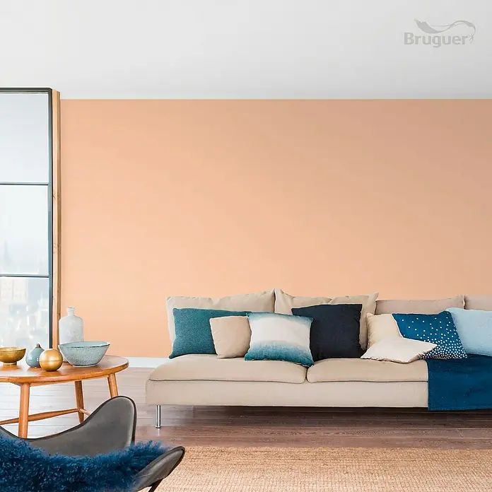 Bruguer Colores del Mundo Tester de pintura - India melocotón suave, Mate, 30 ml - Diseño de pared en melocotón suave con pintura Bruguer. Ambiente acogedor de sala de estar con sofá y cojines coordinados en color.