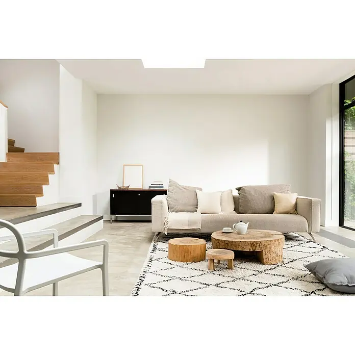 Bruguer Colores del Mundo Tester de pintura - Alaska blanco intermedio, Mate, 30 ml - Salón con sofá beige, mesas de madera y alfombra estampada. Decoración luminosa y moderna con escalera y luz natural.