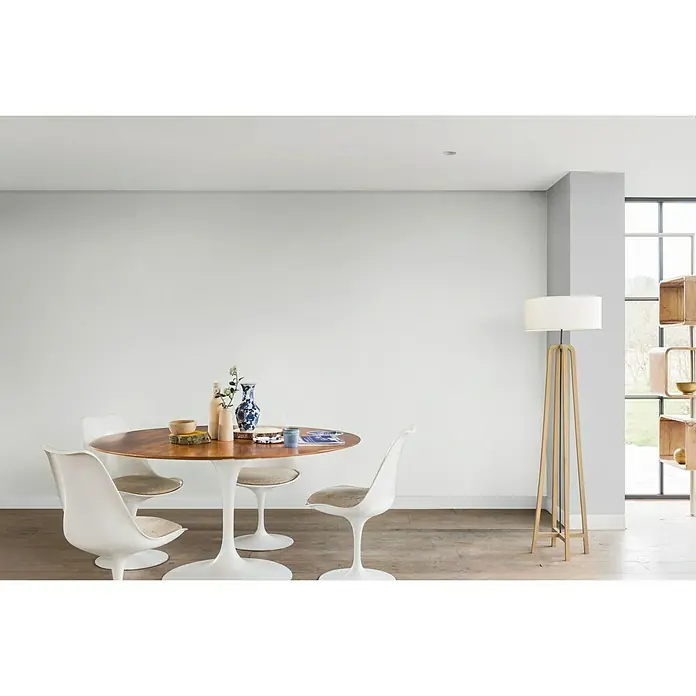 Bruguer Colores del Mundo Tester de pintura - Alaska blanco luminoso, Mate, 30 ml - Comedor con una mesa redonda de madera, sillas tulipán blancas y una lámpara de pie, creando un ambiente moderno y acogedor.