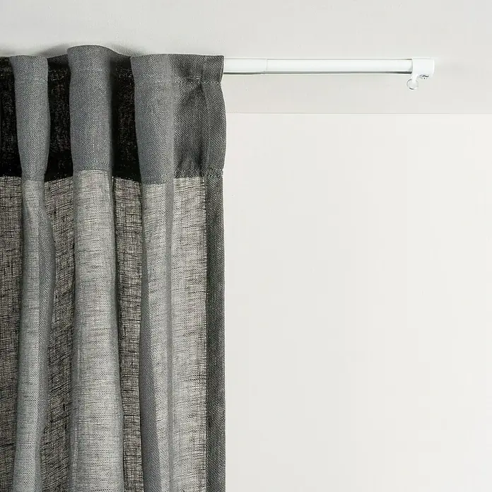 Riel de cortina Basic extensible - L x An x Al: 67 x 2,5 x 1,8 cm, Metal, Blanco - Cortina gris colgada en una barra blanca, aportando una estética moderna y privacidad a cualquier habitación.