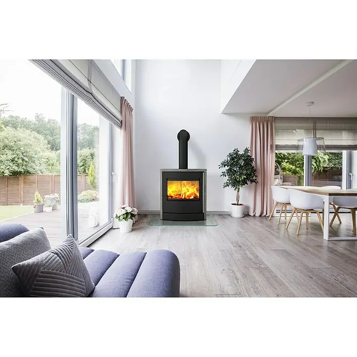 Fireplace Kaminofen Adamis - 3,8 kW - 8,1 kW, Raumheizvermögen: 126 m³, Material Verkleidung: Keramik, Schwarz - Ein moderner Kaminofen im Wohnzimmer, der Wärme und Gemütlichkeit ausstrahlt. Die klaren Linien passen perfekt zum modernen Interieur.